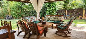 a patio with chairs and a table and a couch at Villa 1 in Jarabacoa