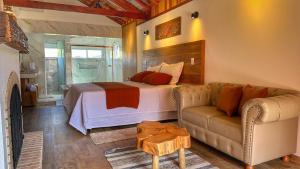uma sala de estar com uma cama e um sofá em Monte Verde Lofts Araucária em Monte Verde
