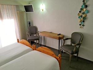 1 dormitorio con 1 cama, mesa y sillas en Hôtel de la Plage à Gland, en Gland
