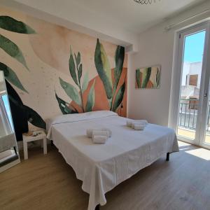 une chambre avec un grand lit avec un tableau au mur dans l'établissement CASA TURCHESE, à Favignana