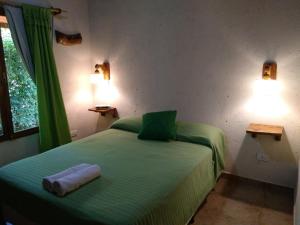 1 dormitorio con 1 cama verde y 2 lámparas en Los Angeles en Villa General Belgrano