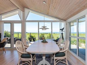 a dining room with a table and chairs and windows at 7 person holiday home in Højslev-By Traum in Højslev