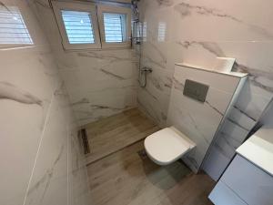 a white bathroom with a toilet and a shower at Beachouse Villa Tatijana in Rogoznica