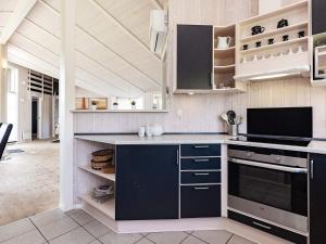 een keuken met blauwe kasten en een fornuis bij 10 person holiday home in Rudk bing in Spodsbjerg