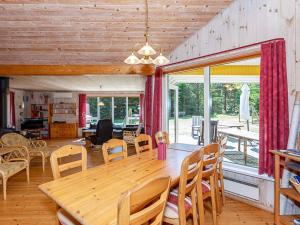 een eetkamer met een houten tafel en stoelen bij 10 person holiday home in H jslev in Bøstrup