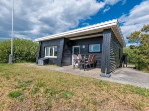 a black tiny house with a table and chairs at Holiday home Fanø CCVII in Fanø
