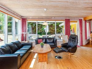een woonkamer met een bank, stoelen en een tafel bij 10 person holiday home in H jslev in Bøstrup