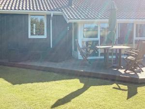 een terras met een tafel en stoelen op een huis bij 6 person holiday home in Strandby in Strandby