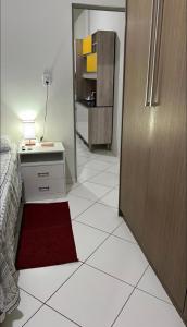 - une chambre dotée d'un tapis rouge sur un sol carrelé blanc dans l'établissement Apartamento em plena Doca, à Belém