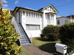 een wit huis met een trap ervoor bij Spacious home close to CBD and Airport in Brisbane