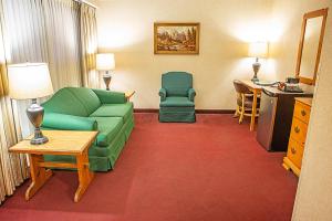 a living room with a couch and chairs in a hotel room at Bavarian Inn Lodge in Frankenmuth