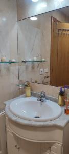 a bathroom with a white sink and a mirror at Villa Paraiso in Villaviciosa