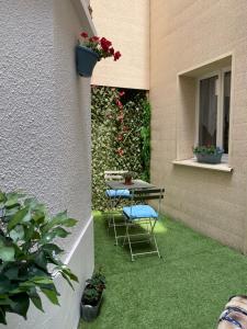 a patio with a table and chairs on the grass at Petite maison hyper centre de Dieppe proche plage in Dieppe