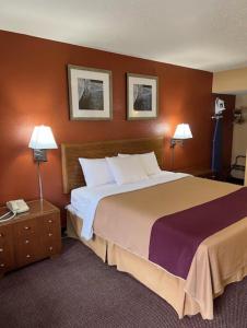 a hotel room with a large bed and two lamps at Executive Inn Schenectady Downtown in Schenectady
