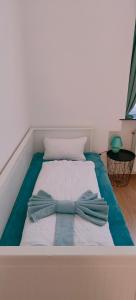 Una cama con una pajarita encima. en Ruyi holiday, en Sopron