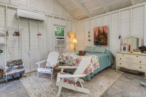 een slaapkamer met een bed en 2 witte stoelen bij Coffeyville Countryside Studio with Fire Pit! in Coffeyville