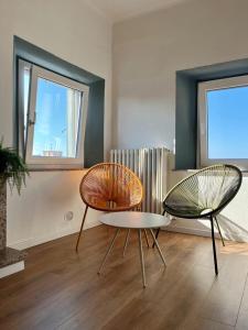 a living room with two chairs and a table at Casa Chiara in Montemarciano