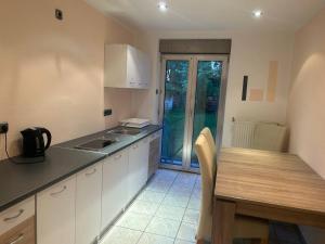 a kitchen with white cabinets and a table and a table and a tableablish at 2 Zimmer Wohnung 1min Messe Köln in Cologne