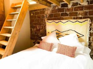 Un dormitorio con una cama blanca con almohadas y una escalera en Casa Piedra Agaete en Agaete
