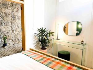 een slaapkamer met een bed en een spiegel bij Casa Piedra Agaete in Agaete