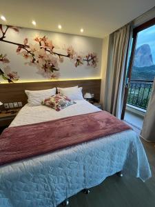 sypialnia z łóżkiem i oknem z drzewem w obiekcie Vista da Pedra Flat w mieście Pedra Azul