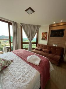 - une chambre avec un grand lit et une grande fenêtre dans l'établissement Vista da Pedra Flat em Pedra Azul, à Pedra Azul