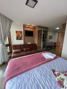 a large bedroom with a large bed with a couch at Vista da Pedra Flat in Pedra Azul