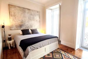 1 dormitorio con 1 cama con una pintura en la pared en Flat Art - Luxury with private Pool & Garden, en Lisboa