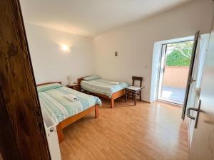 - une chambre avec 2 lits et une porte coulissante en verre dans l'établissement KUĆA ZA ODMOR ROMANO, à Marčana