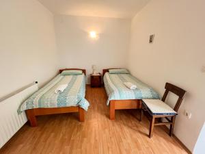 - 2 lits dans une petite chambre avec une chaise dans l'établissement KUĆA ZA ODMOR ROMANO, à Marčana