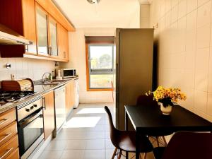 a kitchen with a black table and a black refrigerator at Sweety Bela Vista Apartment in Lisbon