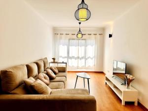 Sweety Bela Vista Apartment في لشبونة: غرفة معيشة بها أريكة وتلفزيون