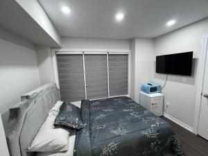 Un dormitorio con una cama y un televisor de pantalla plana. en New Kleinburg Towns, en Woodbridge