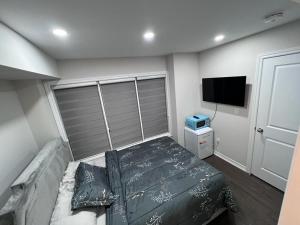 Un dormitorio con una cama y un televisor de pantalla plana. en New Kleinburg Towns, en Woodbridge