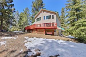 a house with a red deck on a snow covered yard at Cascade Cabin Mountain Getaway with Private Beach in Cascade