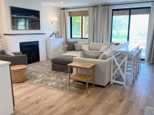 een woonkamer met een bank en een tafel bij Luxury Ski Home 5 min from SnowBasin, 50' from Pineview Lake in Huntsville
