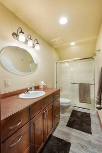 Un baño con lavabo, inodoro y espejo. en Magic McCall Cabin and Studio for Larger Groups wi, en McCall