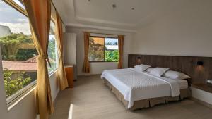 a bedroom with a bed and a large window at Lava House Hostal in Puerto Ayora