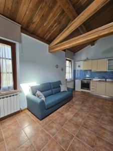 a living room with a blue couch in a kitchen at La Casa dei Tigli in Cannara