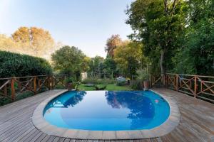 een blauw zwembad op een houten terras bij Seira Sol on 5th in Johannesburg