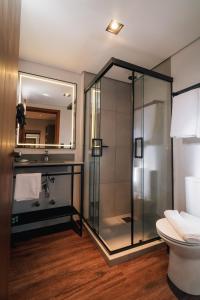 a bathroom with a glass shower and a toilet at 249 DESIGN HOTEL in Gramado