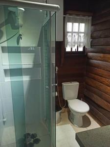 W łazience znajduje się toaleta i przeszklony prysznic. w obiekcie Chalé Castelo Interlagos w mieście Santo Amaro