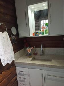 a kitchen counter with a sink and a mirror at Chalé Castelo Interlagos in Santo Amaro