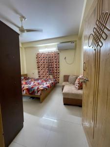 una camera con letto e divano di Shibgonj Bed and Breakfast a Sylhet