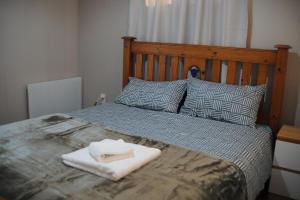 a bed with a wooden headboard and a white towel on it at Endeavour Adventures in Hamilton