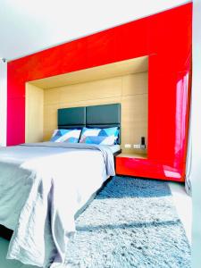 sypialnia z dużym łóżkiem z czerwonym zagłówkiem w obiekcie Cityscape Residences 1102 w mieście Bacolod