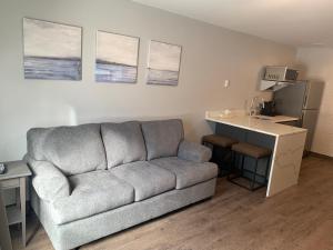 a living room with a couch and a kitchen at Nor Villa Hotel in Winnipeg