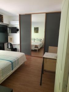 um quarto com uma cama e um espelho em Alain em Noumea