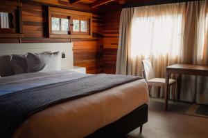 um quarto com uma cama, uma secretária e uma janela em 249 DESIGN HOTEL em Gramado
