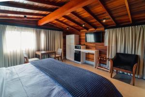 a bedroom with a bed and a desk and a television at 249 DESIGN HOTEL in Gramado